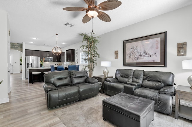 living area featuring ceiling fan, light wood-style flooring, arched walkways, and recessed lighting