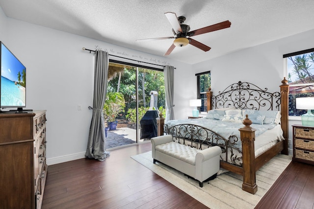 bedroom featuring access to outside, multiple windows, wood finished floors, a textured ceiling, and ceiling fan