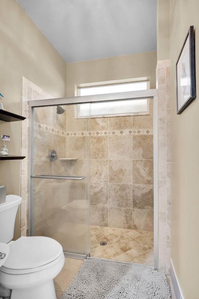 full bathroom with plenty of natural light, toilet, a stall shower, and tile patterned floors