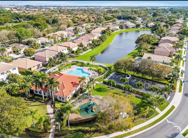 aerial perspective of suburban area featuring a nearby body of water and a pool