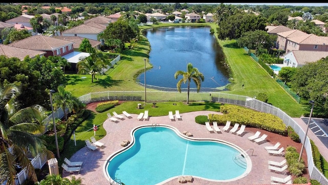 community pool with a water view, fence, a residential view, and a patio area