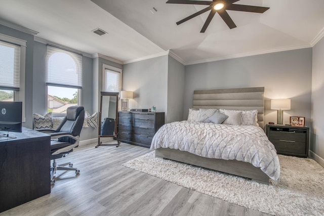 bedroom featuring wood finished floors, baseboards, an office area, crown molding, and a ceiling fan