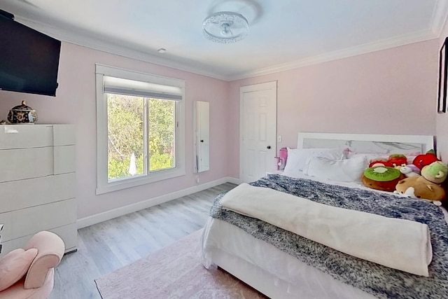 bedroom featuring wood finished floors, ornamental molding, and baseboards