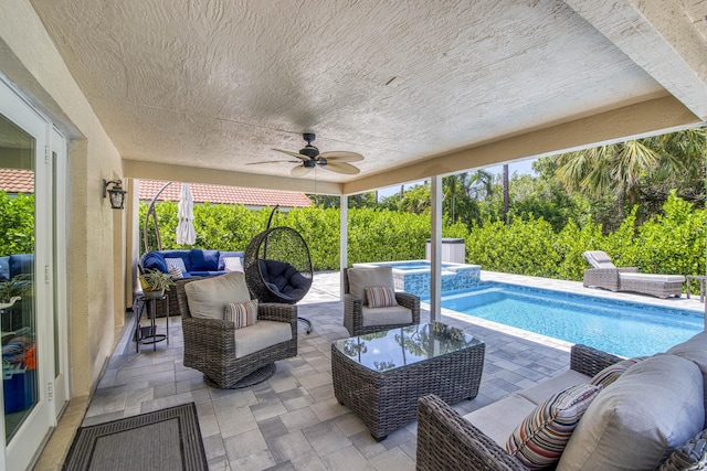 view of pool featuring a patio, ceiling fan, a pool with connected hot tub, and an outdoor living space