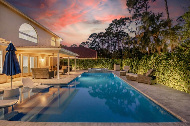 view of pool featuring an outdoor living space, a ceiling fan, a patio area, a pool with connected hot tub, and fence