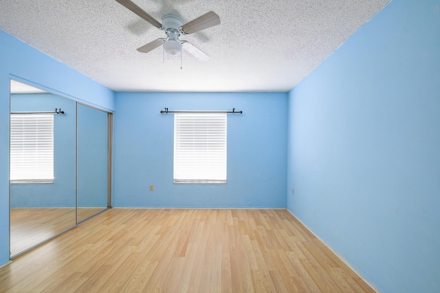 280 NW Airoso Blvd, Port Saint Lucie, FL 34983 - unfurnished bedroom with wood finished floors, a textured ceiling, a closet, ceiling fan, and baseboards