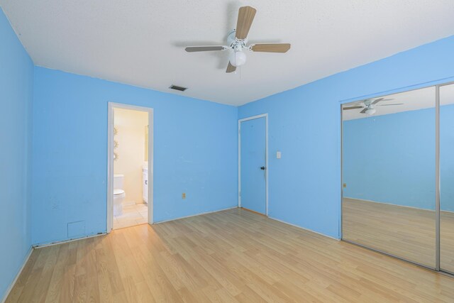 280 NW Airoso Blvd, Port Saint Lucie, FL 34983 - unfurnished bedroom with light wood-style flooring, a closet, a ceiling fan, and connected bathroom