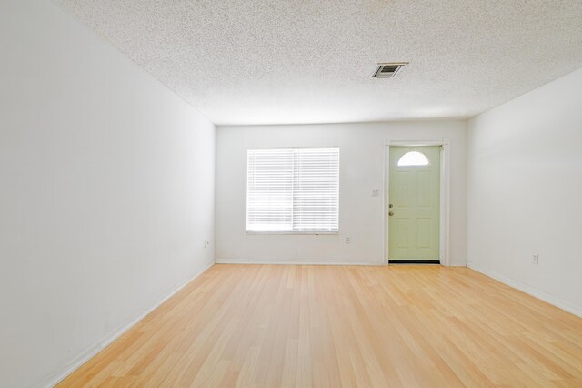 280 NW Airoso Blvd, Port Saint Lucie, FL 34983 - entrance foyer featuring light wood-style flooring, healthy amount of natural light, a textured ceiling, and baseboards