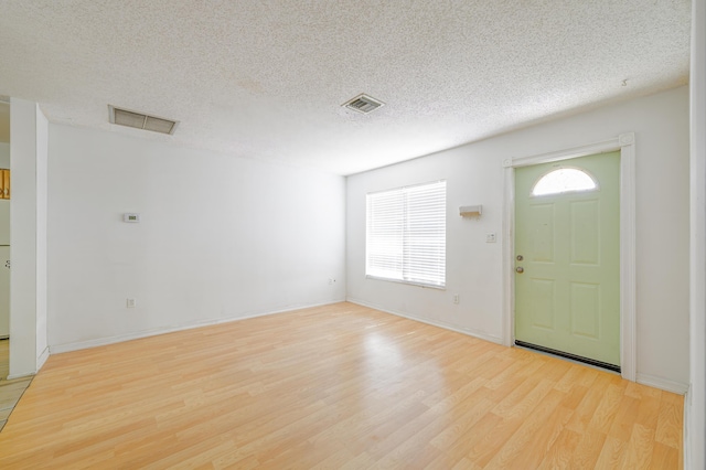280 NW Airoso Blvd, Port Saint Lucie, FL 34983 - foyer featuring light wood-type flooring, healthy amount of natural light, a textured ceiling, and baseboards