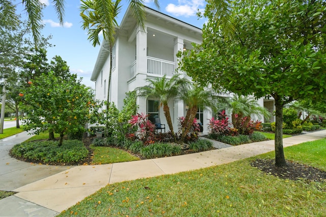6028 Curie Pl, Palm Beach Gardens, FL 33418 - view of front of home featuring a balcony, stucco siding, and a front yard