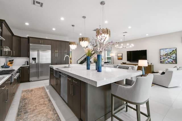 6028 Curie Pl, Palm Beach Gardens, FL 33418 - kitchen with appliances with stainless steel finishes, a sink, a large island, a chandelier, and open floor plan