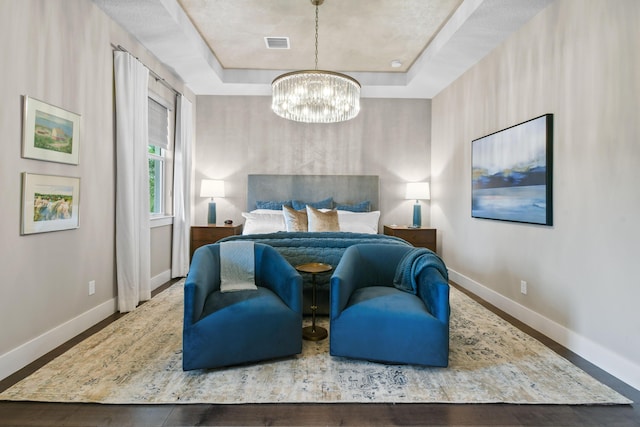 6028 Curie Pl, Palm Beach Gardens, FL 33418 - bedroom featuring baseboards, a chandelier, a tray ceiling, and wood finished floors
