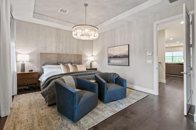 6028 Curie Pl, Palm Beach Gardens, FL 33418 - bedroom with a tray ceiling, baseboards, wood finished floors, and a chandelier