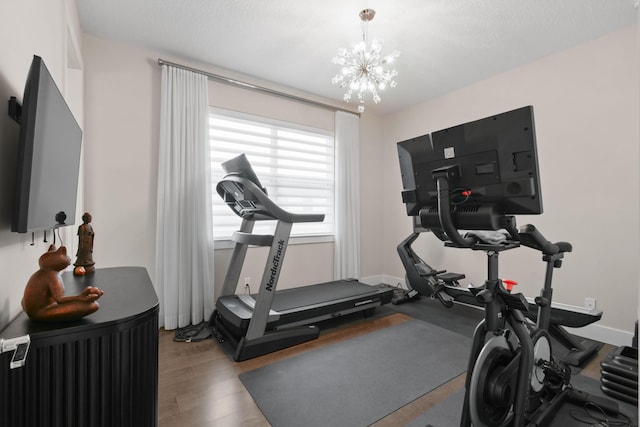 6028 Curie Pl, Palm Beach Gardens, FL 33418 - workout area featuring wood finished floors and a chandelier