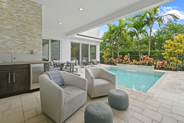 6028 Curie Pl, Palm Beach Gardens, FL 33418 - view of pool featuring a sink, a patio area, an outdoor kitchen, and an outdoor living space