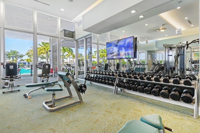 6028 Curie Pl, Palm Beach Gardens, FL 33418 - exercise room with carpet floors, ceiling fan, expansive windows, a high ceiling, and recessed lighting