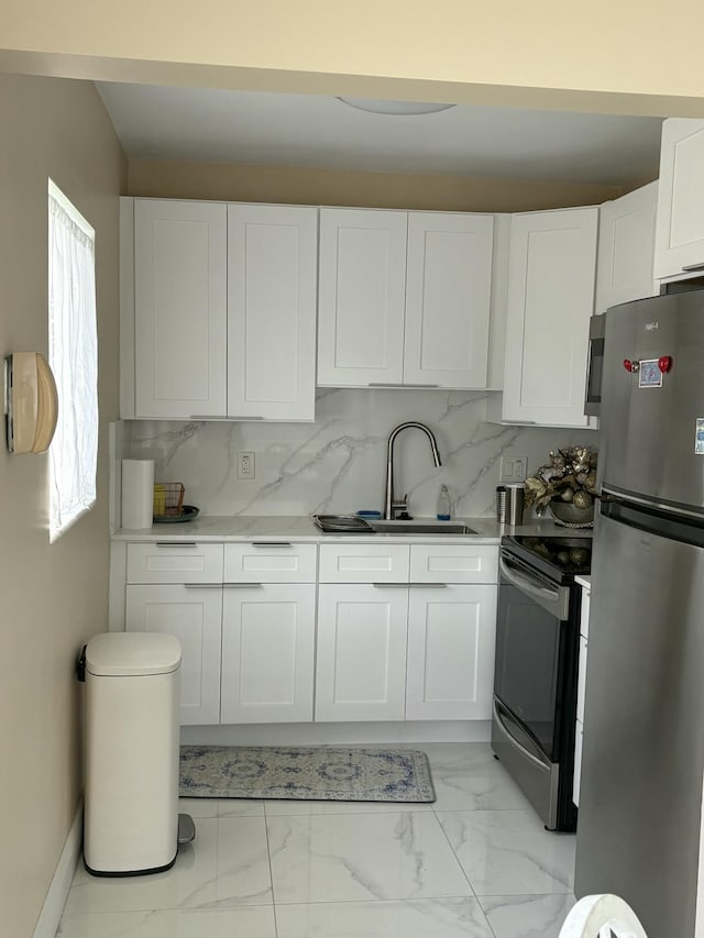 3160 Lake Osborne Dr Unit 201, Lake Worth, FL 33461 - kitchen with stainless steel appliances, a sink, white cabinetry, light marble finish floors, and light countertops