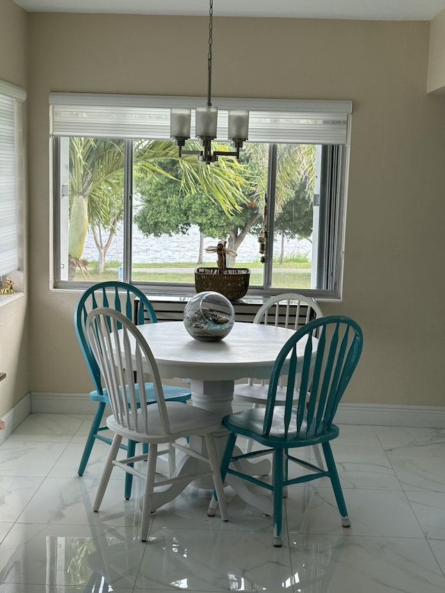 3160 Lake Osborne Dr Unit 201, Lake Worth, FL 33461 - dining space featuring light marble finish flooring, baseboards, a chandelier, and plenty of natural light