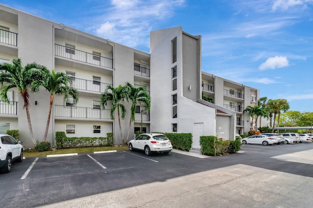 view of apartment building / complex featuring uncovered parking