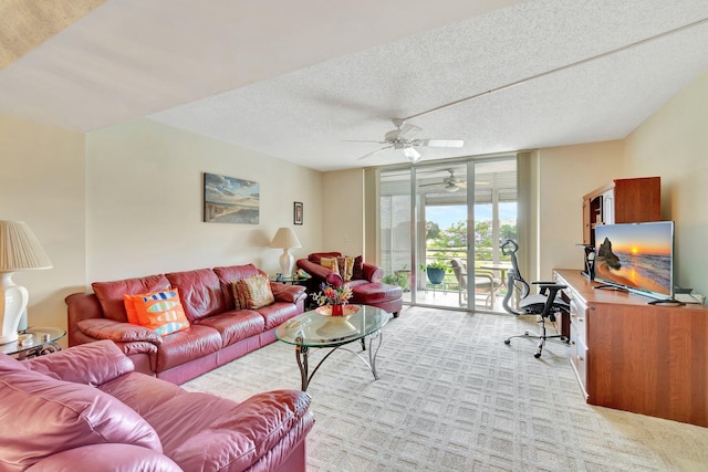 living room featuring ceiling fan, light colored carpet, and a textured ceiling
