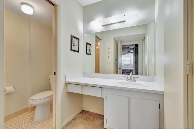 bathroom with toilet, baseboards, and vanity