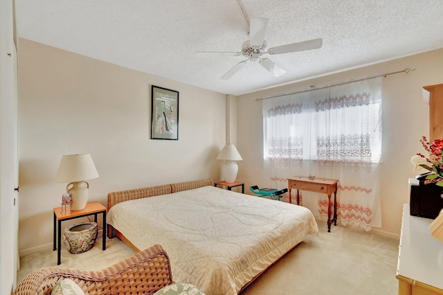 carpeted bedroom featuring a textured ceiling and a ceiling fan