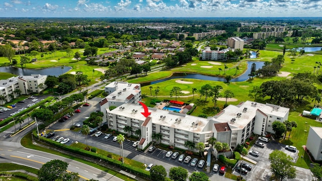 aerial view of apartment complex / building, a golf course, and a large body of water