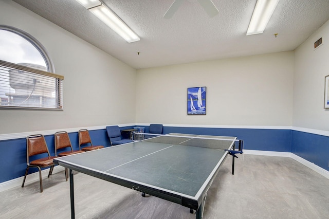 rec room with a textured ceiling and baseboards