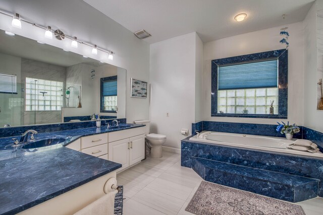 2720 SE Kern Rd, Port Saint Lucie, FL 34984 - full bath featuring a stall shower, toilet, double vanity, a garden tub, and tile patterned flooring