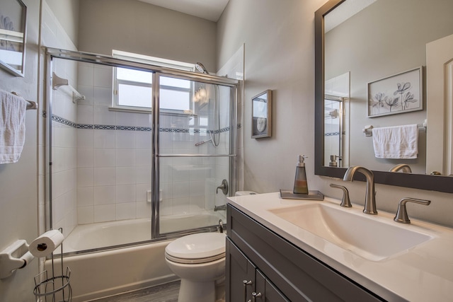 2720 SE Kern Rd, Port Saint Lucie, FL 34984 - full bath featuring toilet, vanity, enclosed tub / shower combo, and wood finished floors