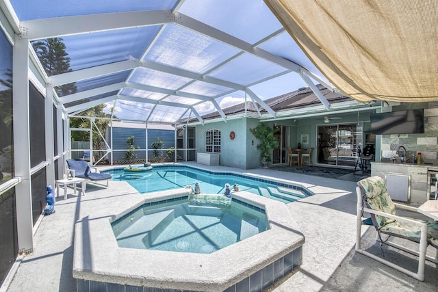 2720 SE Kern Rd, Port Saint Lucie, FL 34984 - view of swimming pool featuring a patio, a pool with connected hot tub, a storage unit, and glass enclosure
