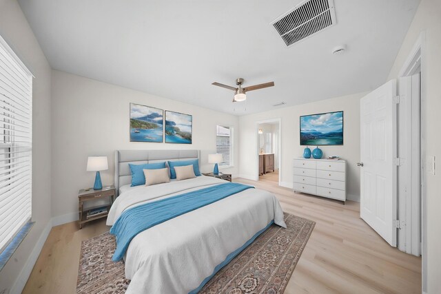 3227 SW Foremost Dr, Port Saint Lucie, FL 34953 - bedroom with light wood finished floors, baseboards, a ceiling fan, and ensuite bath