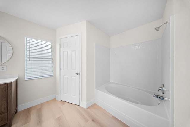 3227 SW Foremost Dr, Port Saint Lucie, FL 34953 - full bathroom with vanity, washtub / shower combination, wood finished floors, and baseboards