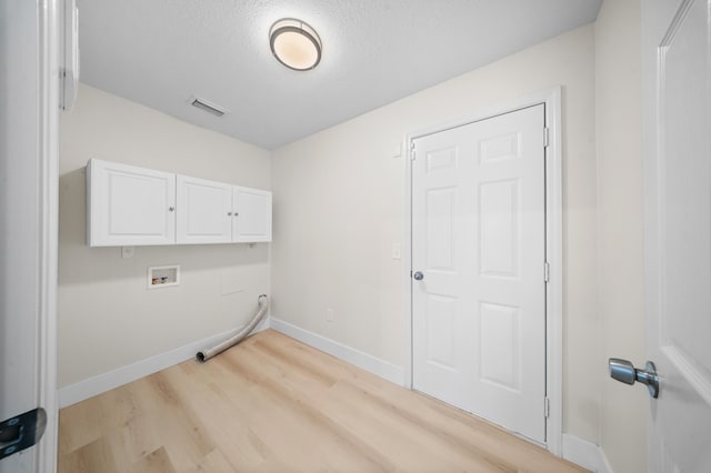 3227 SW Foremost Dr, Port Saint Lucie, FL 34953 - clothes washing area with cabinet space, light wood-type flooring, hookup for a washing machine, a textured ceiling, and baseboards