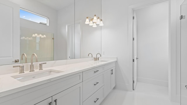 bathroom with double vanity and a chandelier