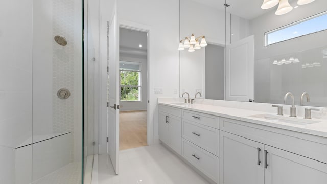 full bath with healthy amount of natural light, a tile shower, and double vanity
