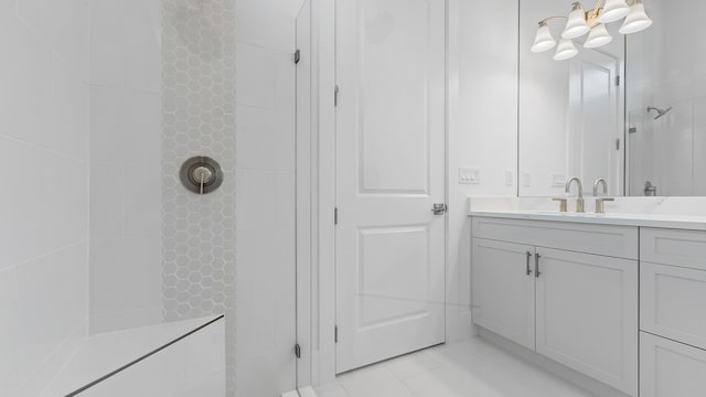 full bath with a tile shower, vanity, a chandelier, and tile patterned flooring