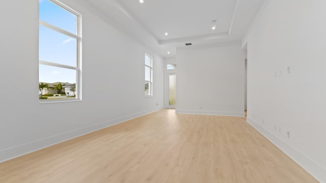 spare room with light wood-style floors, healthy amount of natural light, recessed lighting, and baseboards