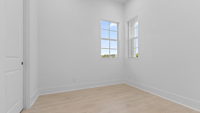 spare room featuring light wood-style floors and baseboards