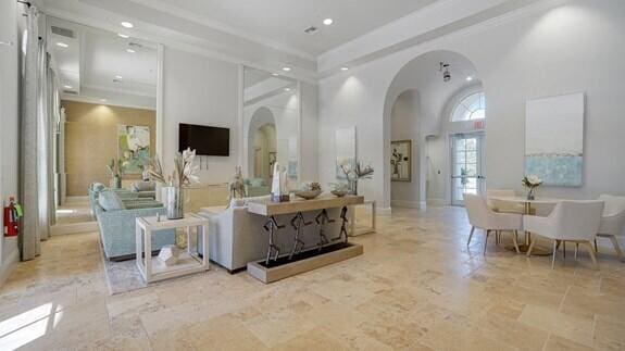 living room with arched walkways, a towering ceiling, and recessed lighting