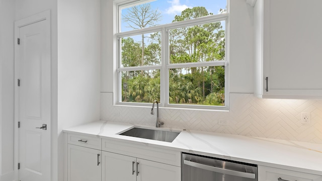 bar featuring a sink, stainless steel dishwasher, and decorative backsplash