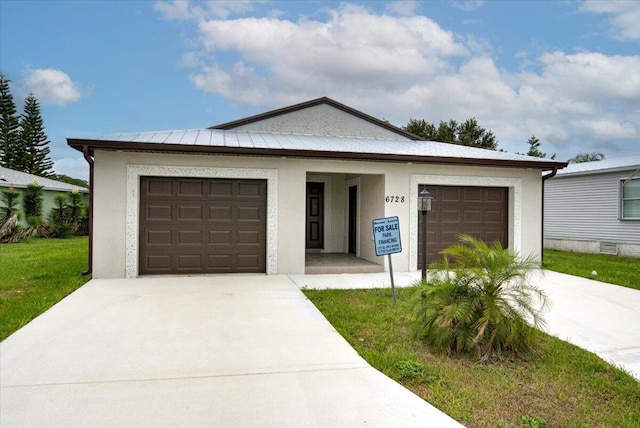 6728 Spanish Lake Blvd, Fort Pierce, FL 34951 - view of front of home with driveway, stucco siding, an attached garage, and a front lawn