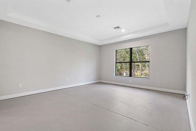 6728 Spanish Lake Blvd, Fort Pierce, FL 34951 - spare room featuring a tray ceiling, concrete floors, baseboards, and recessed lighting