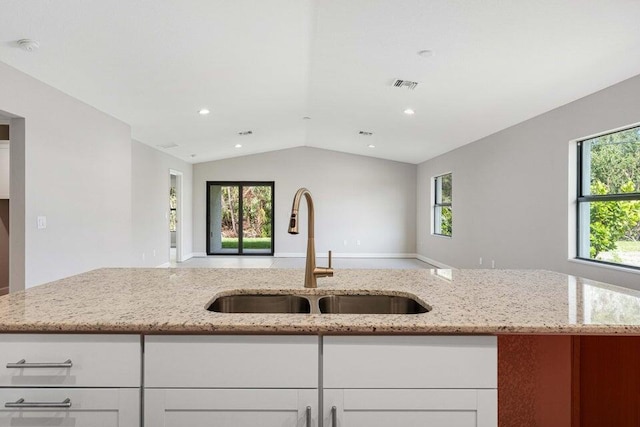 6728 Spanish Lake Blvd, Fort Pierce, FL 34951 - kitchen with a sink, open floor plan, light stone counters, lofted ceiling, and white cabinetry
