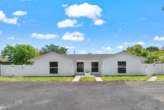 4498 NW 2nd Ave, Boca Raton, FL 33431 - view of front facade featuring a gate, fence, and stucco siding