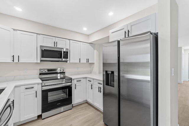 4498 NW 2nd Ave, Boca Raton, FL 33431 - kitchen with appliances with stainless steel finishes, white cabinets, light stone counters, light wood-style floors, and recessed lighting