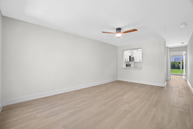 4498 NW 2nd Ave, Boca Raton, FL 33431 - unfurnished living room featuring light wood-style flooring, a ceiling fan, and baseboards