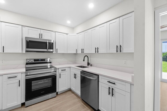 4498 NW 2nd Ave, Boca Raton, FL 33431 - kitchen featuring stainless steel appliances, a sink, white cabinets, and recessed lighting
