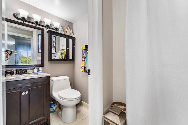 bathroom featuring toilet, vanity, tile patterned flooring, a shower with shower curtain, and baseboards