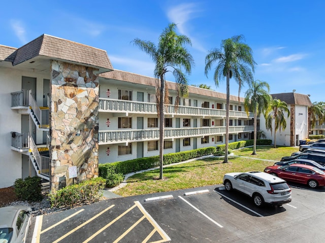 view of apartment building / complex with uncovered parking